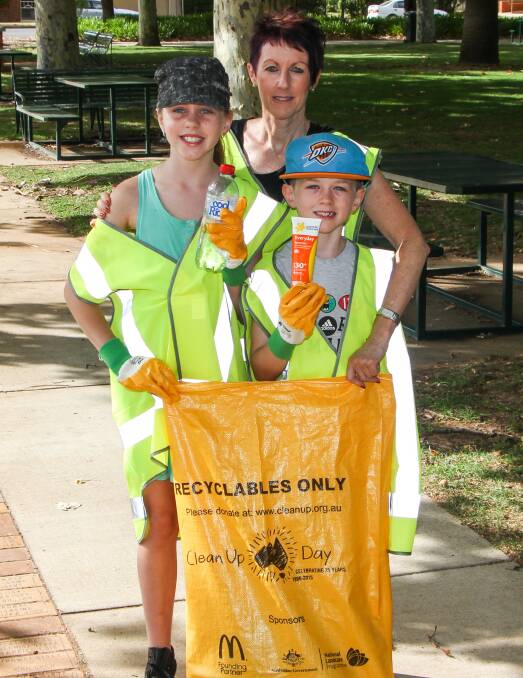 TIDY: Charlotte, 10, and Eddie Morschel, 6, with Leeton Public School's assistant principal Gena Frazer during Clean Up Australia Day on Sunday. 