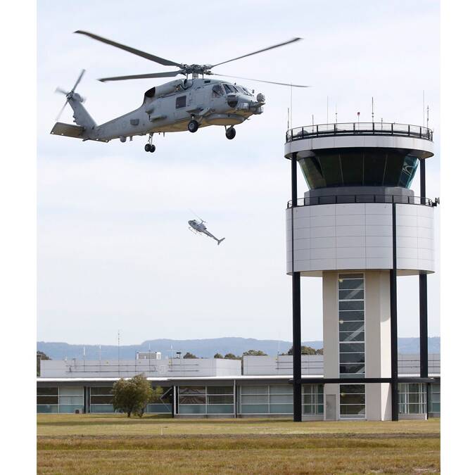 GREAT SHOT: Former HMAS Albatross photographer Kel Hockey’s photo of one of the RAN’s new Romeo Seahawks hovering next to the air traffic control tower at Albatross, with a Squirrel helicopter in the background going almost vertical which won the Rosemary Rodwell Memorial Prize.