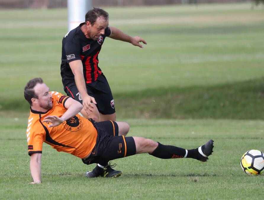 TACKLE: Wagga United's Lincoln Weir arrives to tackle Leeton United's Nick Trifogli in the game at Rawlings Park on Sunday. Picture: Les Smith
