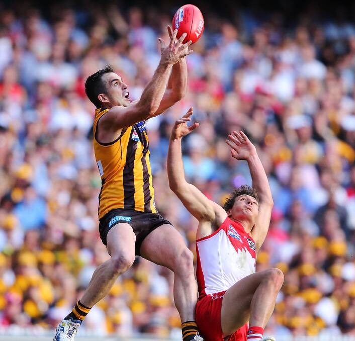 SCREAMER: Former Hawthorn player Brian Lake takes a big mark over Sydney's Kurt Tippett during last year's AFL season. Photo: Getty Images 