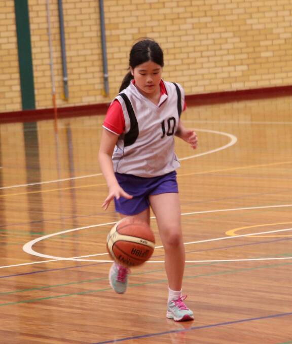 FORWARD THINKING: Ella Tang runs the ball up during Monday night's semi-finals of the junior basketball competition.