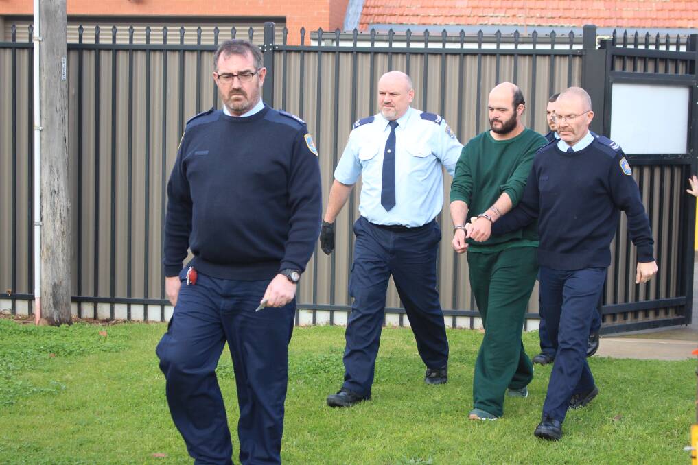 Marcus Stanford being led into the Leeton court last week. 