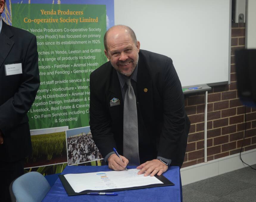 PEN TO PAPER: Leeton Shire Council deputy mayor George Weston officially signs on to the project. 