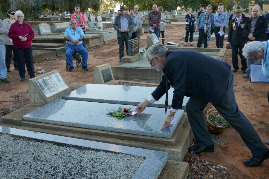 Leeton Shire Council mayor Paul Maytom lays a posy on one of the graves visited. Photo: Christoper Senti