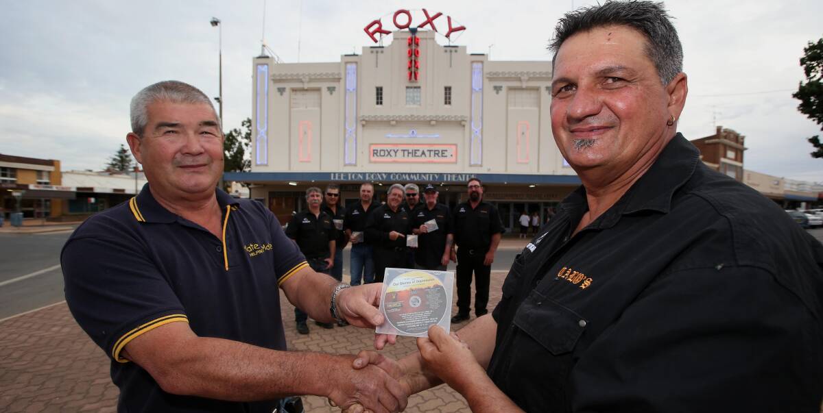 ASSISTANCE: Mate Helping Mate founder John Harper (left) receives the DVD from Calo's club president Pat Tripodi, while members stand in support behind. Photo: Anthony Stipo 