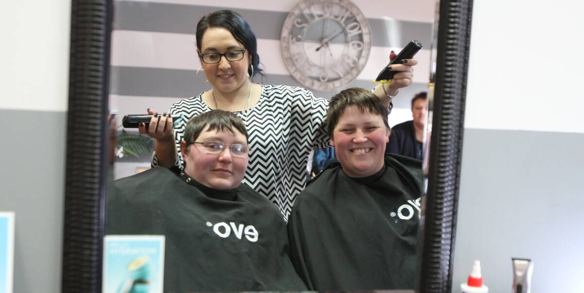 CLIPPER TIME: Jody Smith (left) and Cassandra Wilson prepare to have their heads shaved by hairdresser Sandra Nardi as part of fund-raising for their Relay for Life team. 