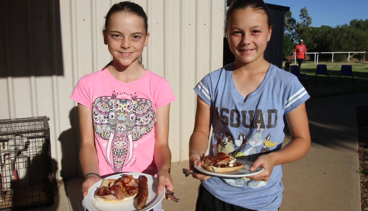 YUMMY: Makayla, 11, and Kristen Bradshaw, 10, prepare to tuck into their delicious barbecue breakfast at the Murrami Australia Day event on Thursday. Photo: Talia Pattison 