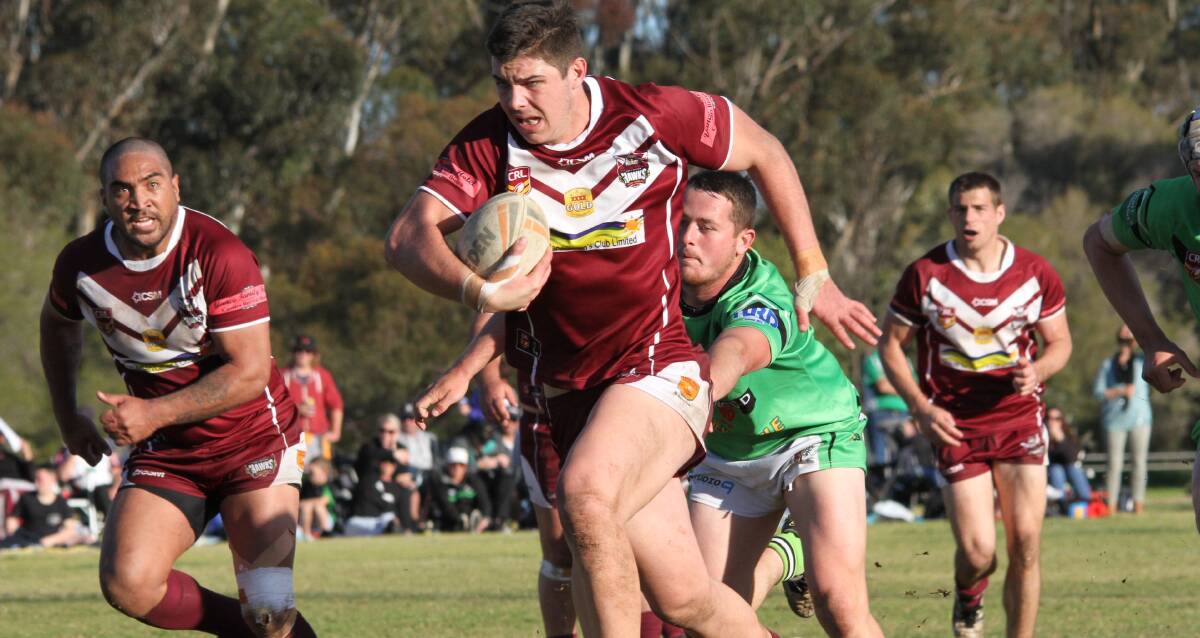 ON FIRE: Hawks player Zac Saddler stays just out of Bas Blackett's reach as he powers his way through the Greens defensive line on Sunday. Photo: Ron Arel