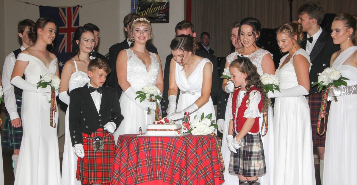 DIVING RIGHT IN: The debutantes and their partners watch as Chelsea Axtill cuts into the cake at the 58th Scottish Debutante Ball. Photo: Ron Arel