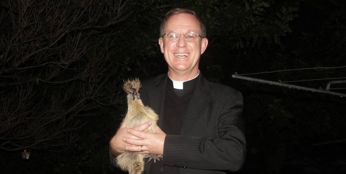 HAPPY: Father Robert Murphy with one of his chooks. Fr Robert enjoys all the many different aspects to life in Leeton. Photo: Ron Arel 