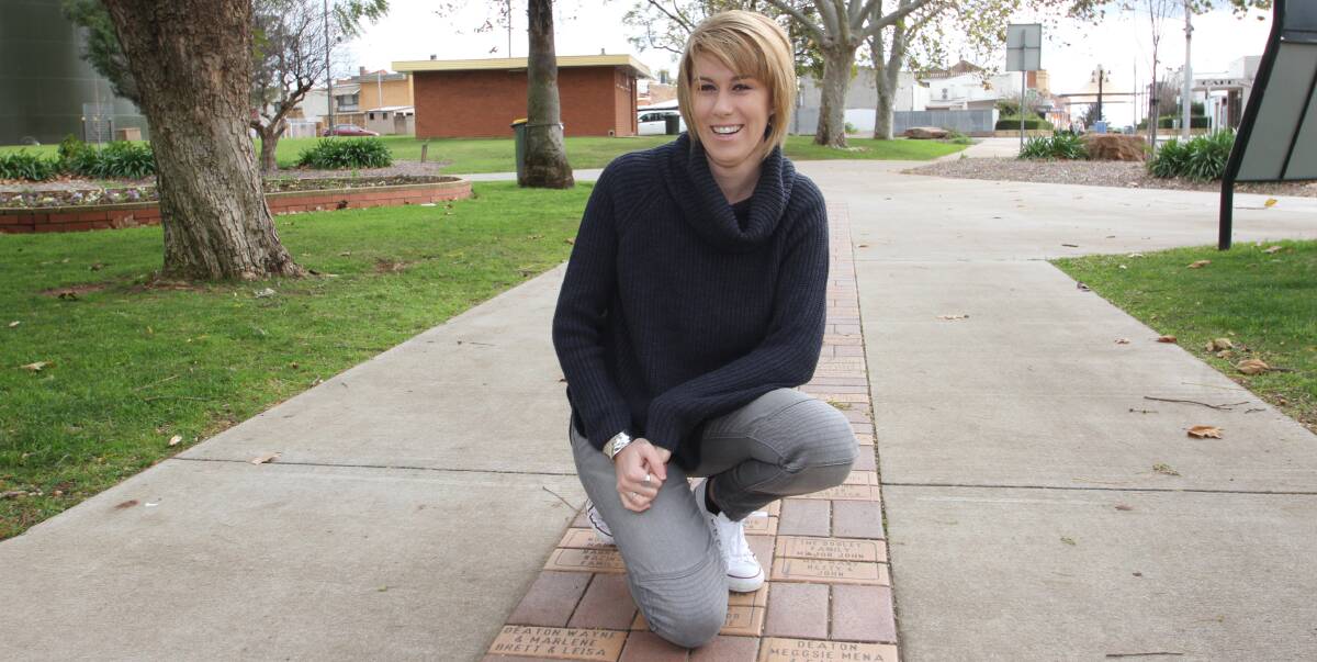 KNEELING NEXT TO HISTORY: Tara Bowe looks over the engraved bricks representing her family and their connection to Leeton over the years. Photo: Ron Arel