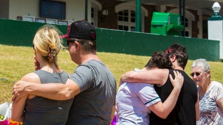 Locals grieve outside Dreamworld on Wednesday following Tuesday's fatalities. Photo: Glenn Hunt