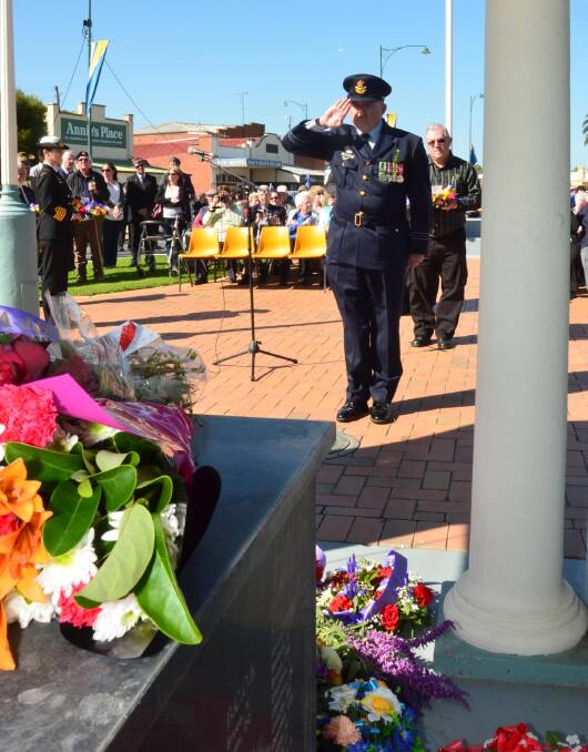 Anzac Day in Junee. Squadron Leader Peter Hogarth salutes after placing a wreath. Picture: Declan Rurenga 