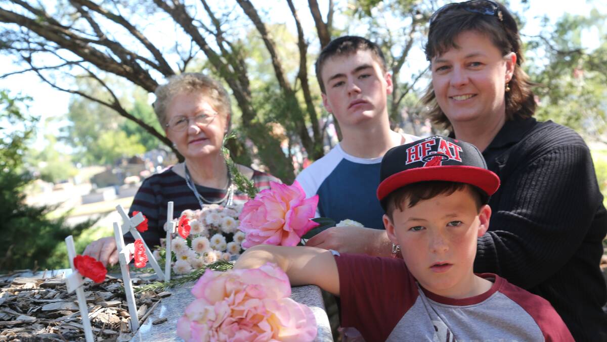 Anzac Day in Griffith. The Burley family - Maureen, Reid, 14, Kylie and Sam, 9, placing a flower on soldier's graves. Picture: Anthony Stipo 