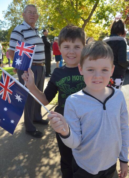 Anzac Day in Junee. Riley, 10, and Cody Hacket, 9, wave their flags during the march.  Picture: Declan Rurenga 