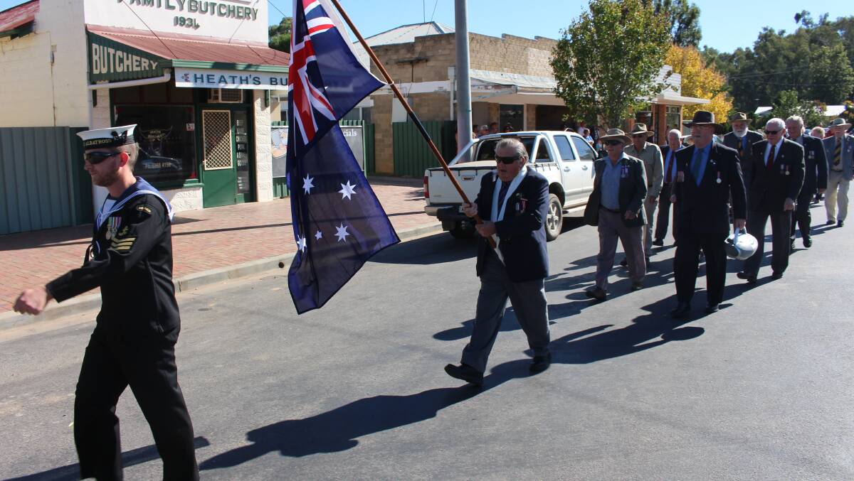 Anzac Day in Darlington Point. The march is led by leading seaman, avionics technician Edric Pound and the flag was carried by Tom Rawson. Picture: Jack Morphet