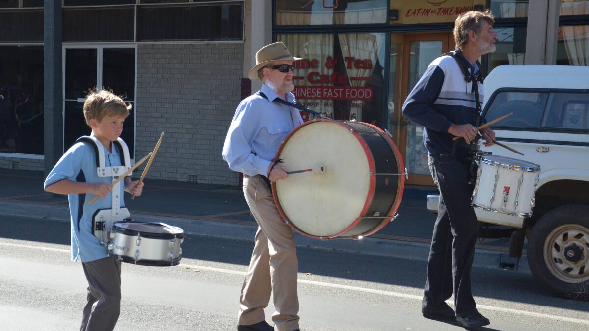 Anzac Day in Junee. Josh Hogarth, 12, Nick Lehmann and Noel "Tack" Lawrence keep the beat for marchers. Picture: Declan Rurenga 