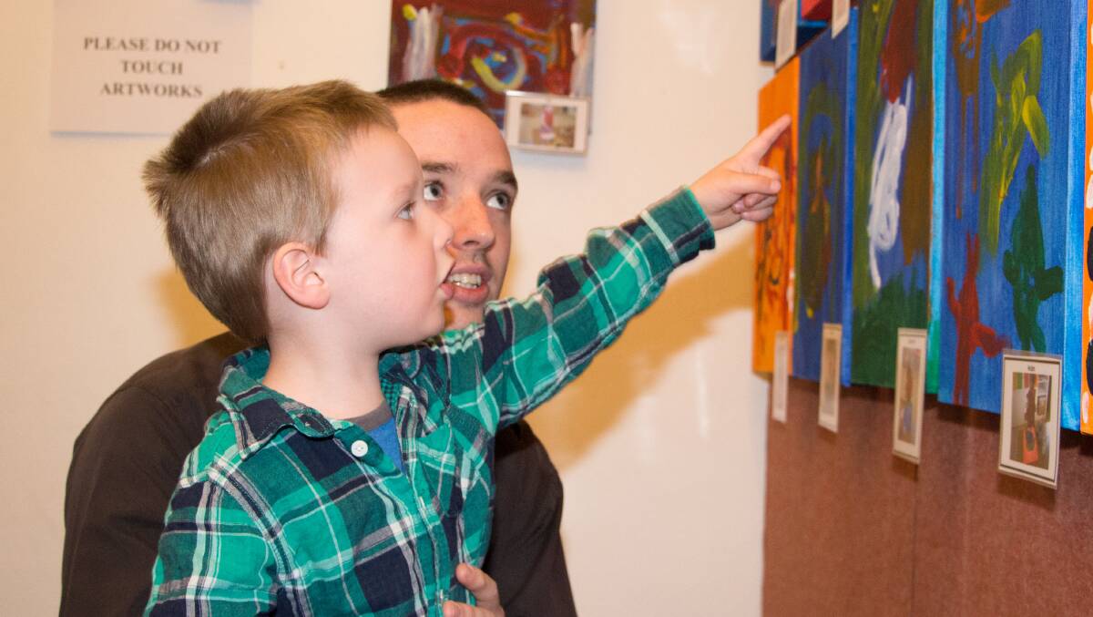 AEDEN O'Leary, 3, points out the expert brushwork in his painting to his father Derick.