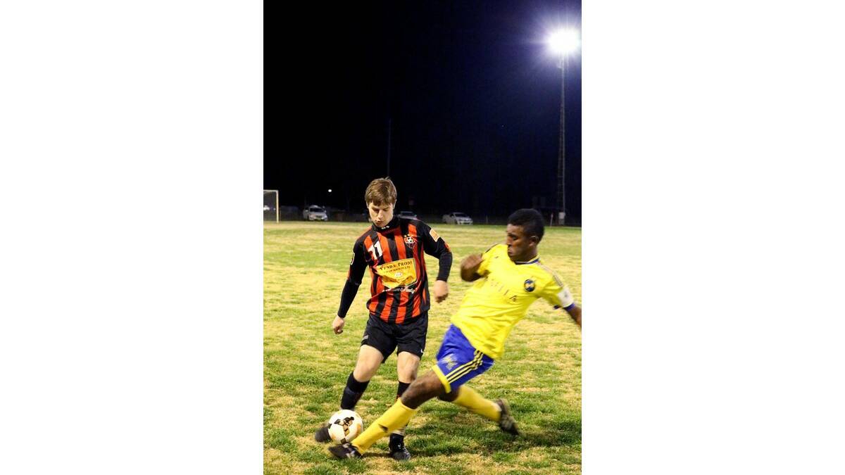 UNITED'S Ian McCarthy is confronted by Yoogali FC's Ura Loki in their elimination final at Noe Santolin Oval.