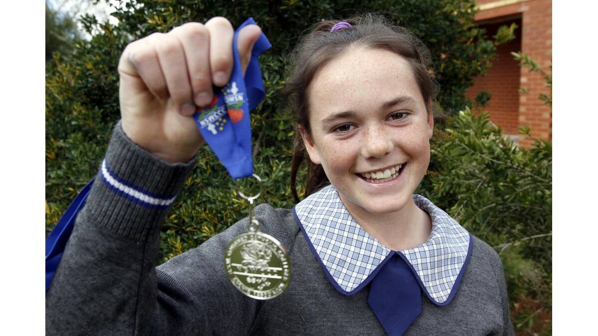 TESS Staines shows off her silver medal she won in the under 13s javelin at the Combined Catholic Colleges (CCC) state athletics carnival.