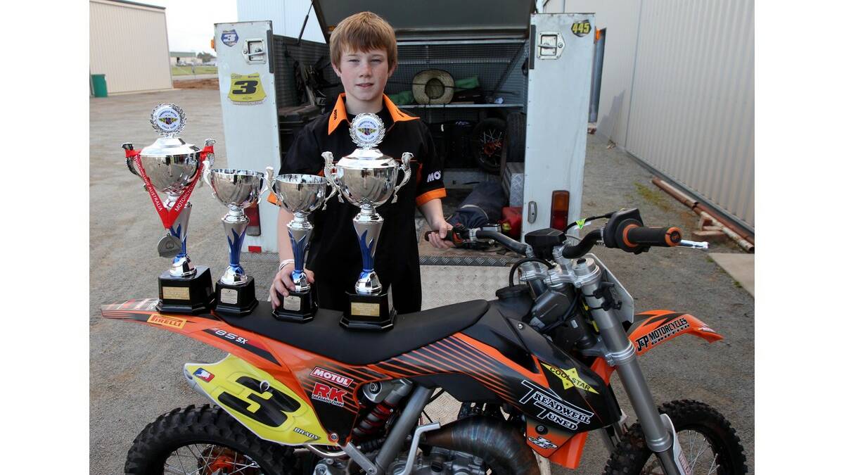 KRUSE Brady, 11, with the range of trophies he has won so far this year in dirt track racing.