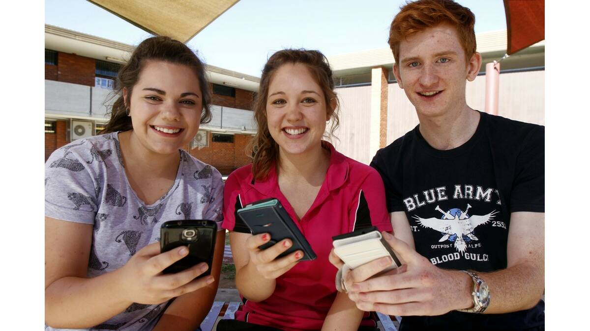 LEETON High School year 12 students (from left) Annalise Ramponi, 17, Sally Boardman, 18 and Ben Keith, 18, check their ATARs on their phones at the year 12 HSC breakfast last Thursday.
