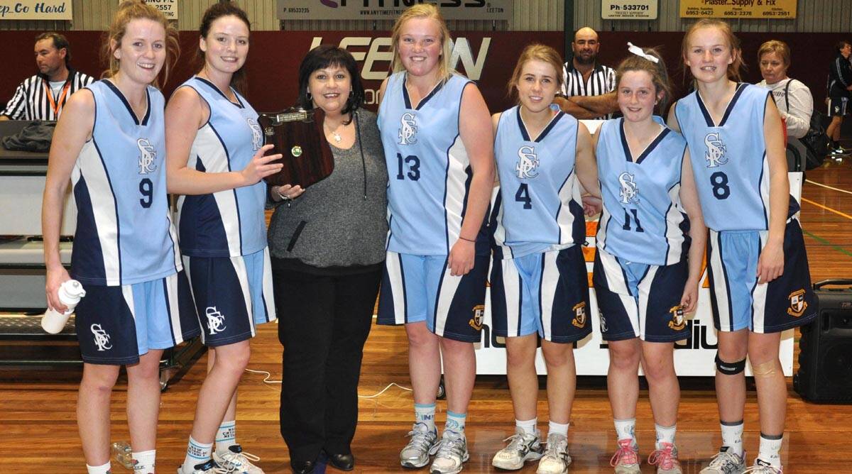 SISTER of the late Dom Fondacaro, Elenor Fondacaro (third from left), presents the victorious St Francis College women's team with the shield named in his honour (from left) Stephanie Clancy, Megan Flynn, Hannah Hyde, Gabby Preston, Reuben Bennett and Maddy Clyne.