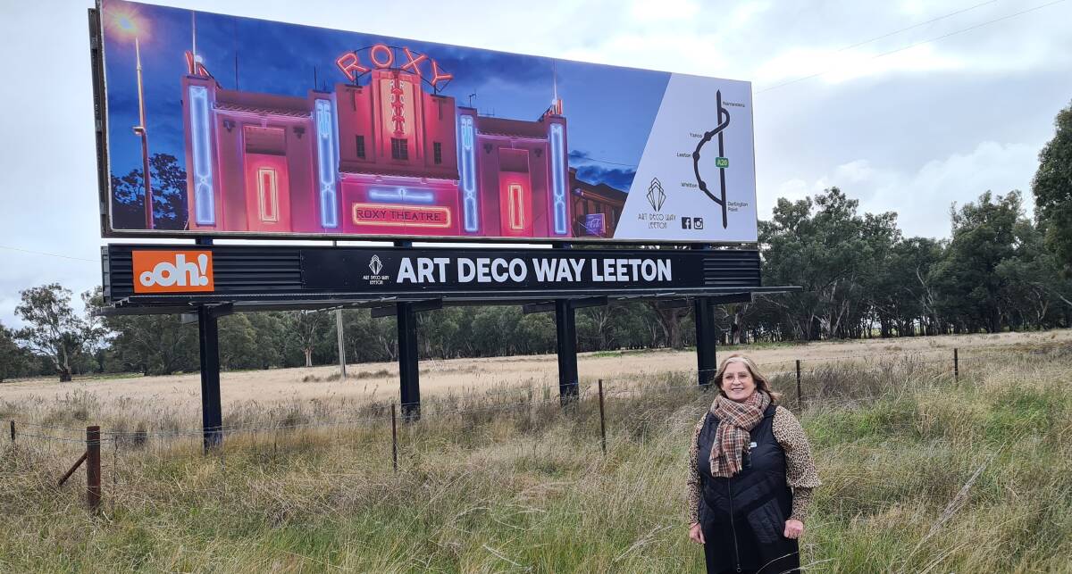 INLAND: Leeton Shire Council's Kathy McMahon in front of a new Art Deco Way Leeton billboard installed on the Sturt Highway near Narrandera. PHOTO: Contributed