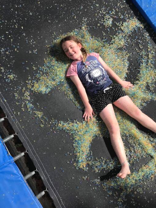FUN IN THE SUN: Ruby Martin makes orbie angels on the trampoline. Picture: ARaePhotography.