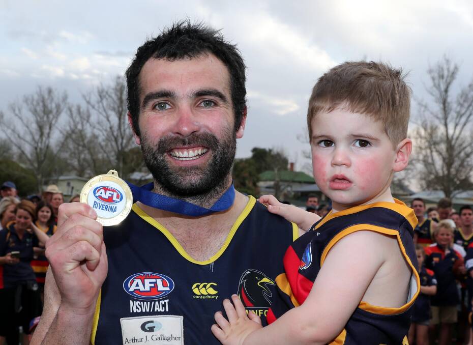 COMEBACK: Leeton-Whitton's Bryce O'Garey with son Boston after being named best on ground in the Crows' 2017 grand final win. Picture: Les Smith