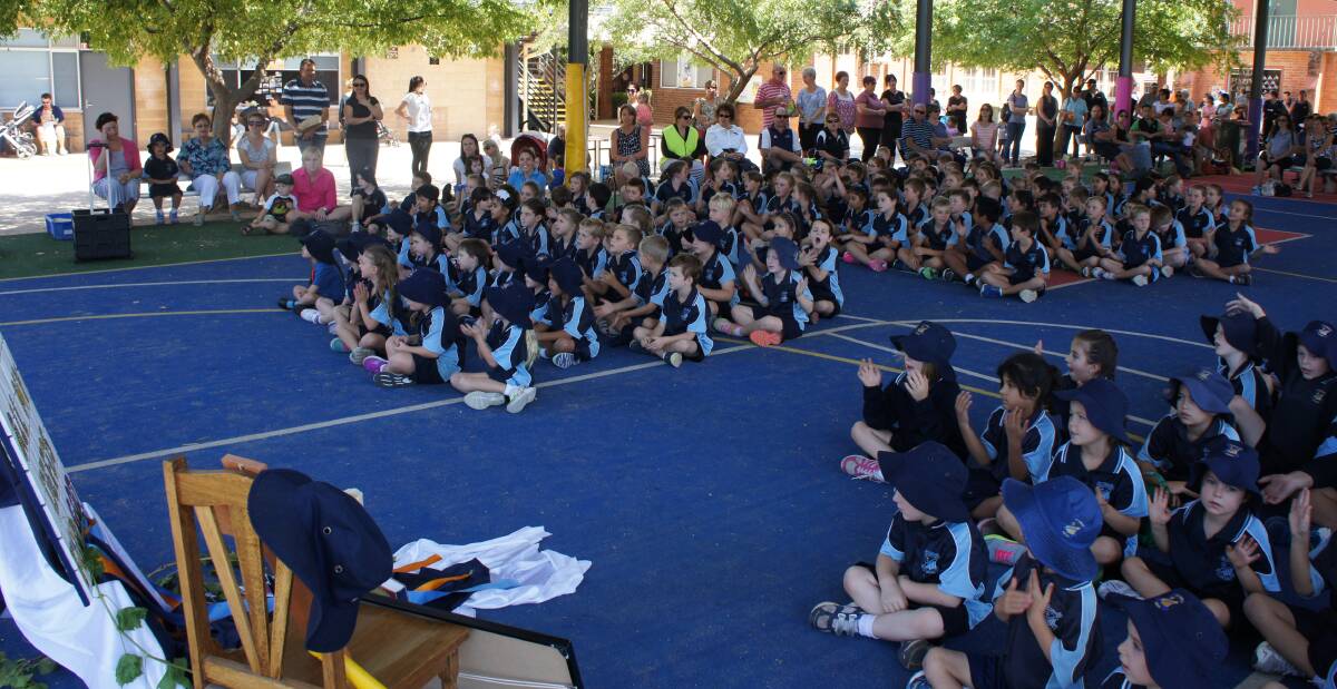 ST JOSEPH'S Primary students gather under the school's covered outdoor learning area (COLA) for an assembly, also attended by parents and other family members.
