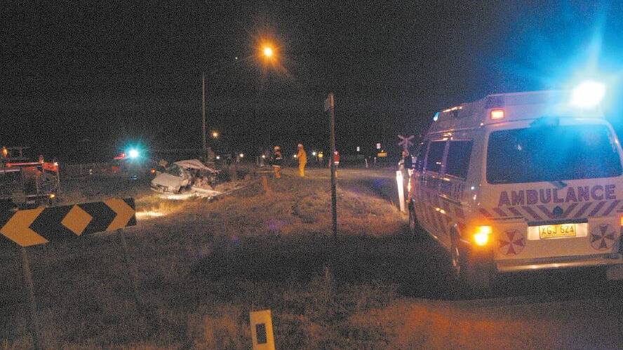 2004: Emergency crews bring some light to the dark crash scene at the Poplar Avenue level crossing on Wednesday night.
