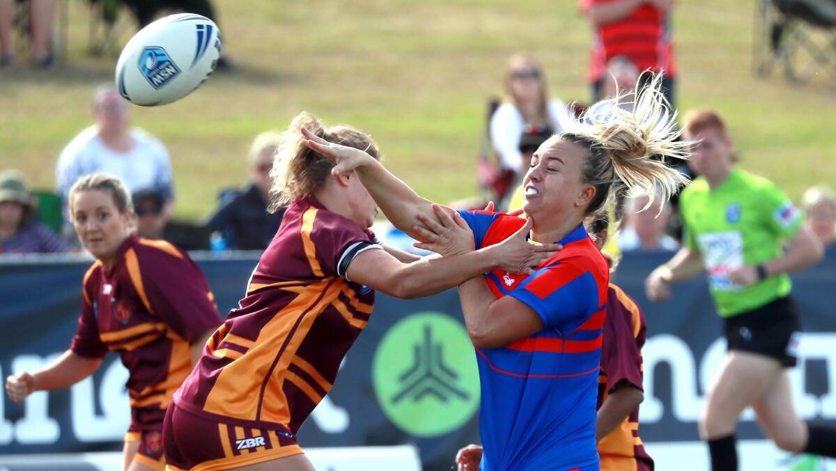 BIG WIN: Sophie Higgins fires off a pass under pressure from the Riverina defence during Newcastle-Maitland Region's win in the Country Championships final on Saturday. Picture: Les Smith
