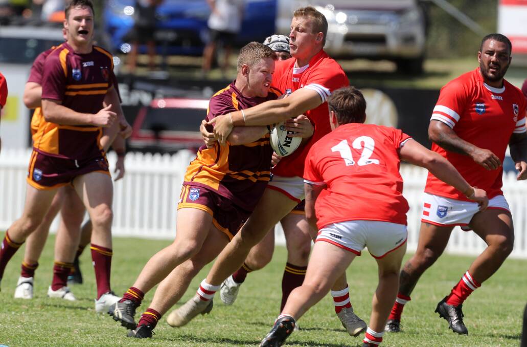 MOVING ON: Hayden Philp tries to break out of a tackle during Riverina's win over Illawarra South Coast in the Country Championships on Sunday. Picture: Robert Peet