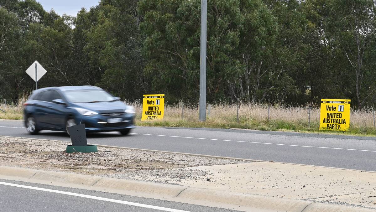 Changing drivers: A car passes United Australia Party placards. The candidate for the Clive Palmer-funded group has switched from Louis Ramos to his wife Julie. Picture: MARK JESSER