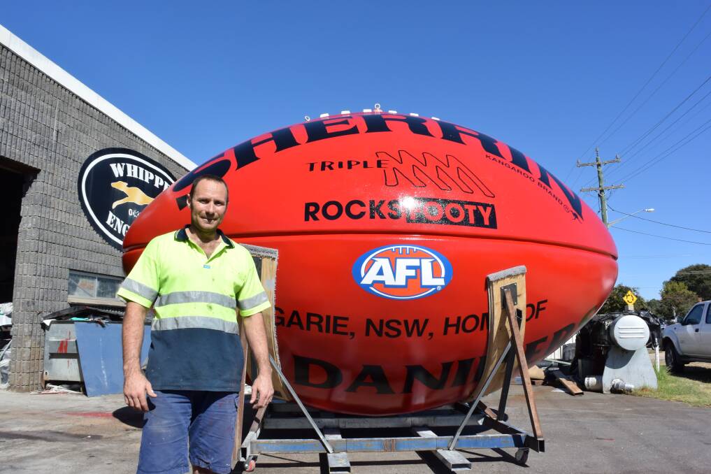 On the ball: Aaron Wilkinson at his workshop with the 800-kilogram football built to honour the Daniher family at Ungarie in the northern Riverina. The brainchild of the Ungarie Advancement Group will be unveiled on Saturday.
