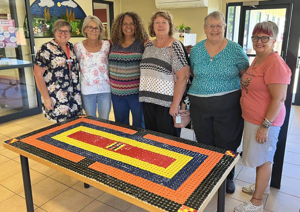 Library staff member Rachel Cody with (from left) Roslyn Beard, Deb Fernando, Sherri Jones, Helen Symes and Stephanie McCallum show one of the finished mosaic products. Picture supplied