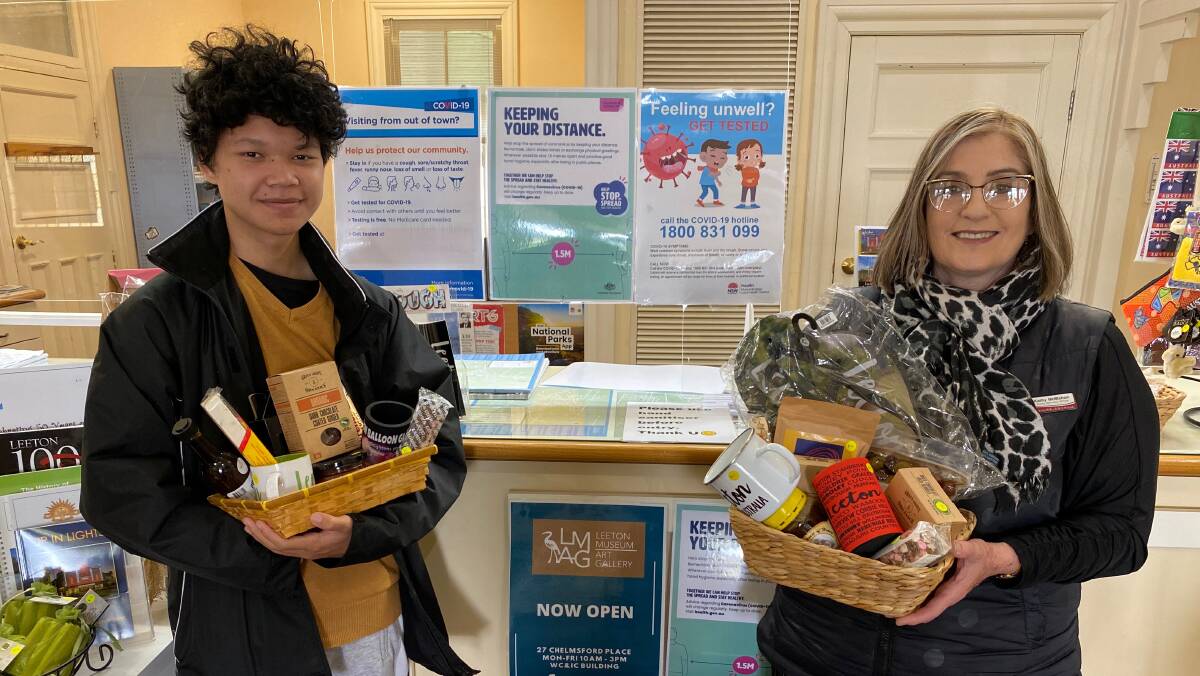 HELP OUT: Visitor services officer Kathy McMahon (right) and Eh Htoo from Leeton High School, who is assisting at the centre as part of the WIN program, show off the Father's Day gift packs. Photo: Talia Pattison 