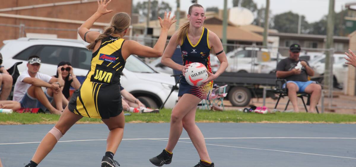 ON COURT: Leeton-Whitton's Carley Graham searches for a team mate during a match against Wagga Tigers last season. 