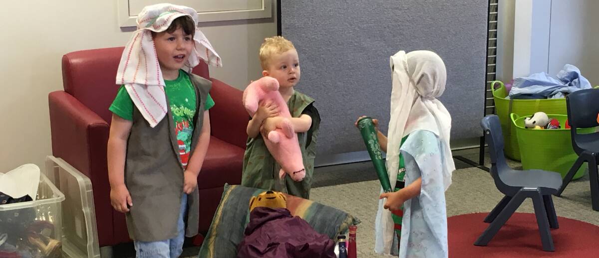 ROLE TO PLAY: Youngsters Harvey Bruno, 4, Matthew Kroek, 2, and Ariadne Rowe, 2, help tell the nativity story during the Christmas-themed storytime. 