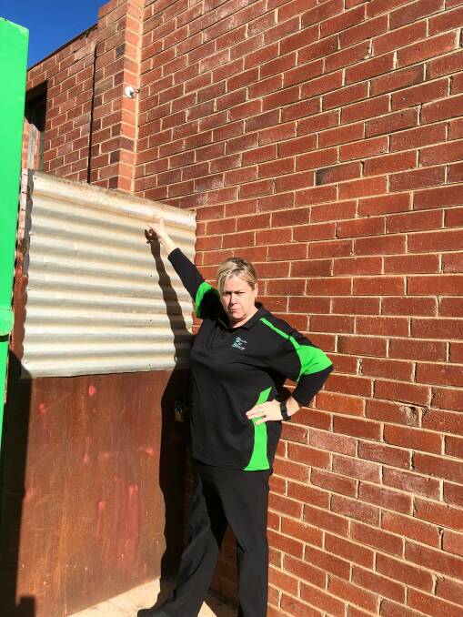 UNIMPRESSED: Leeton Community Op Shop manager Jodie Ridge points out where the CCTV camera used to be before it was cut down and stolen from the outside of the store's building. Photo: Talia Pattison 