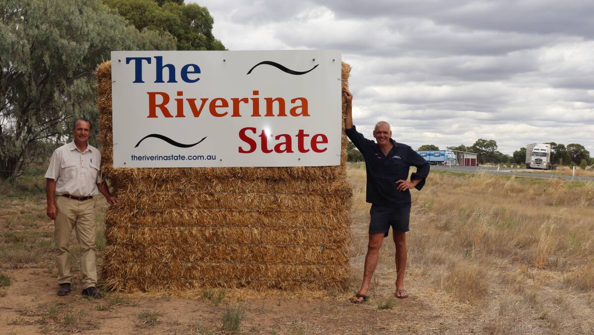 PUSH: David Landini (left) with Martin Cincotta and at the temporary Riverina State sign on the side of the road near the Barham truck stop in early January. Photo: Contributed