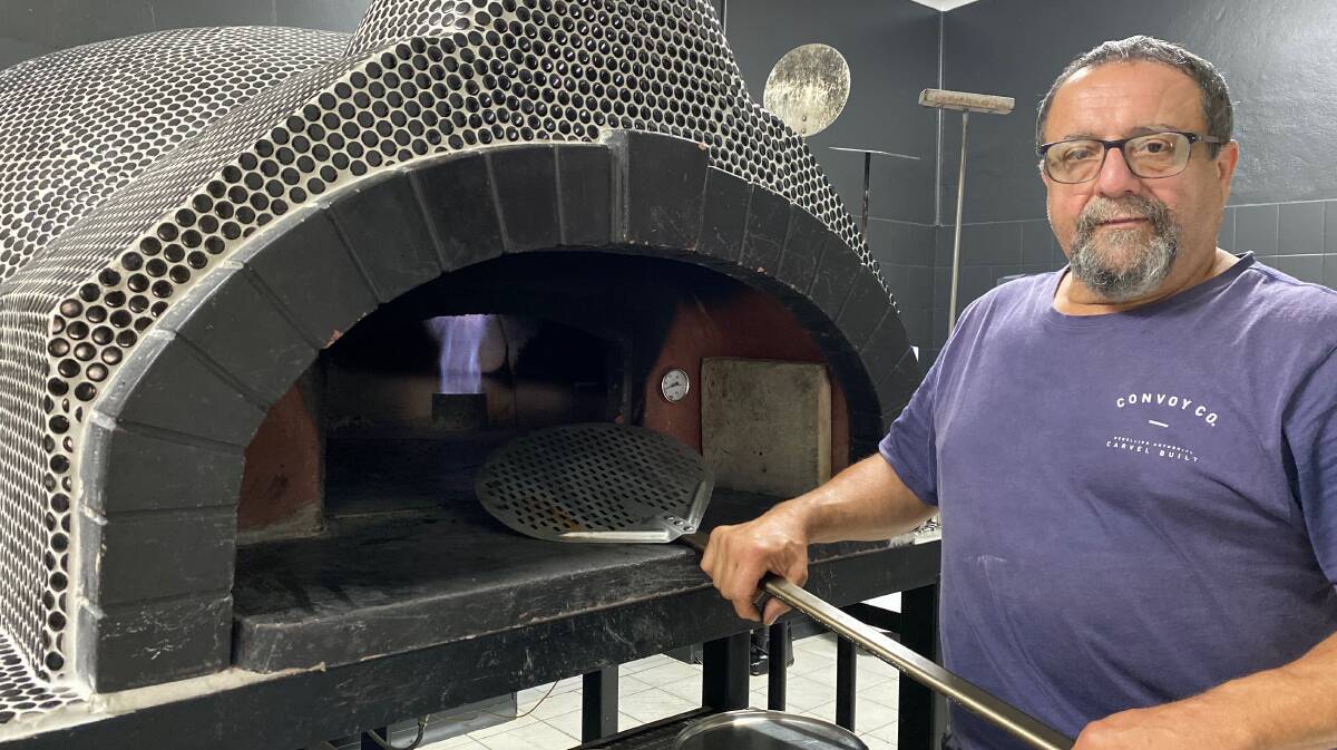 FEAST: Michael Nardi shows off the woodfire pizza oven, which he put together on site, as well as a stone (inside, far right), which was taken from his mum's bread oven that she used back in the day. Photo: Talia Pattison