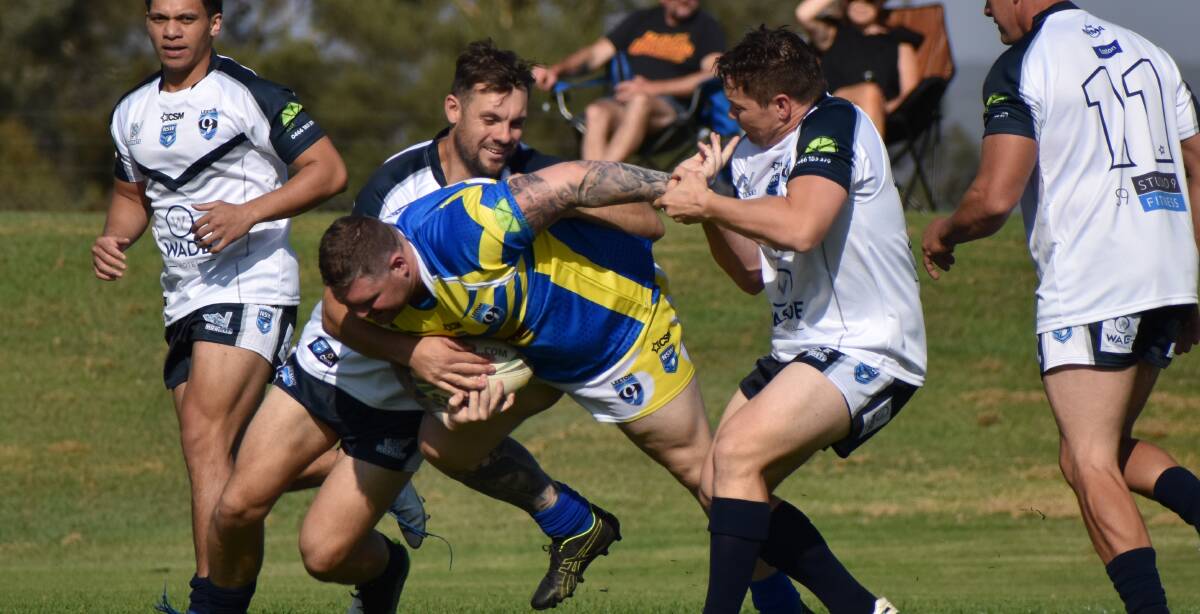 STRENGTH: Joel Dempsey does his best to break through this tackle during round one of the Leeton Community Cup. Photo: Shaun Paterson 