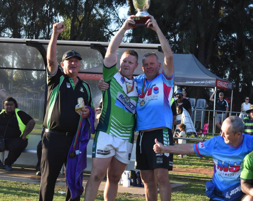 Leeton Greens president Col Fisher (left) with Hayden Philp and Paul McGregor hoisting the first grade premiership cup on grand final day. Picture by Liam Warren