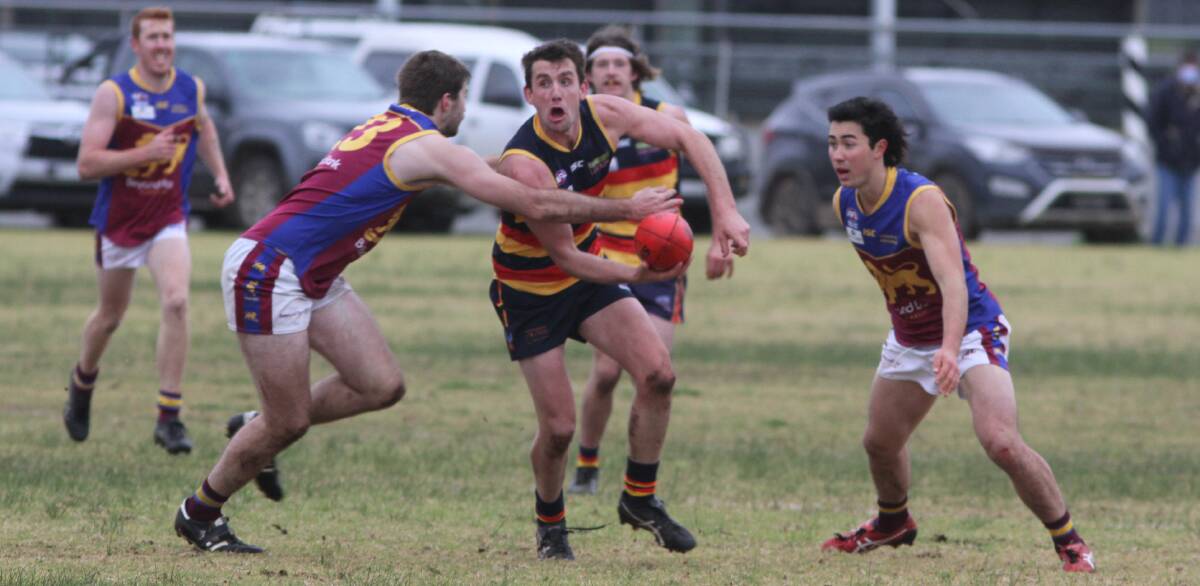 UNDER PRESSURE: Leeton-Whitton's Tom Meline attempts to get a handball away during Saturday's clash with Ganmain-Grong Grong-Matong. Photo: Talia Pattison