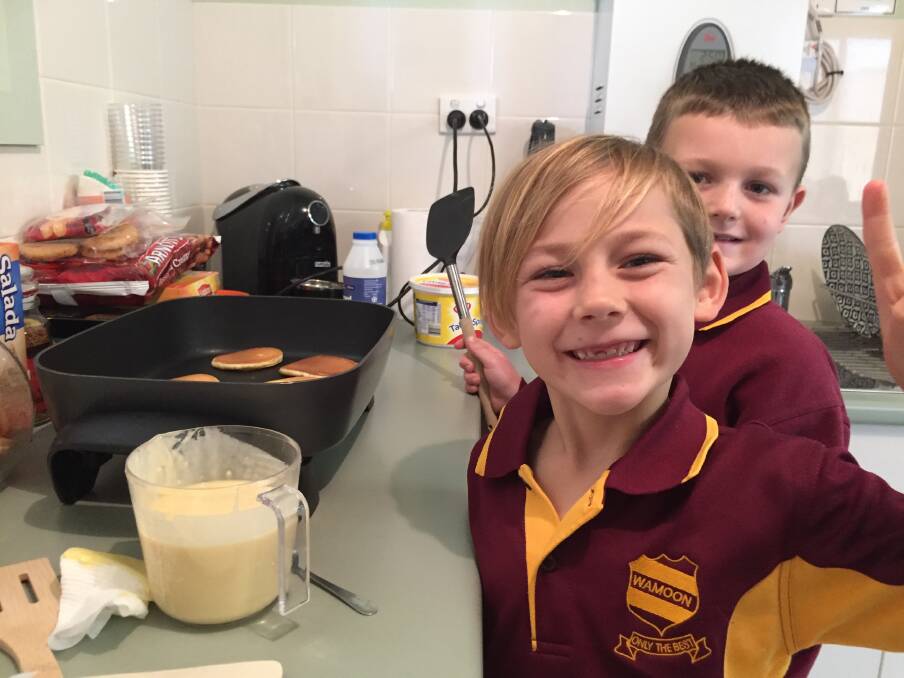 GREAT FUN: Nash Tuckett (back) and Dane Bradshaw (front) have a blast making pancakes as part of the chaplaincy program at Wamoon Public School. Photo: Contributed