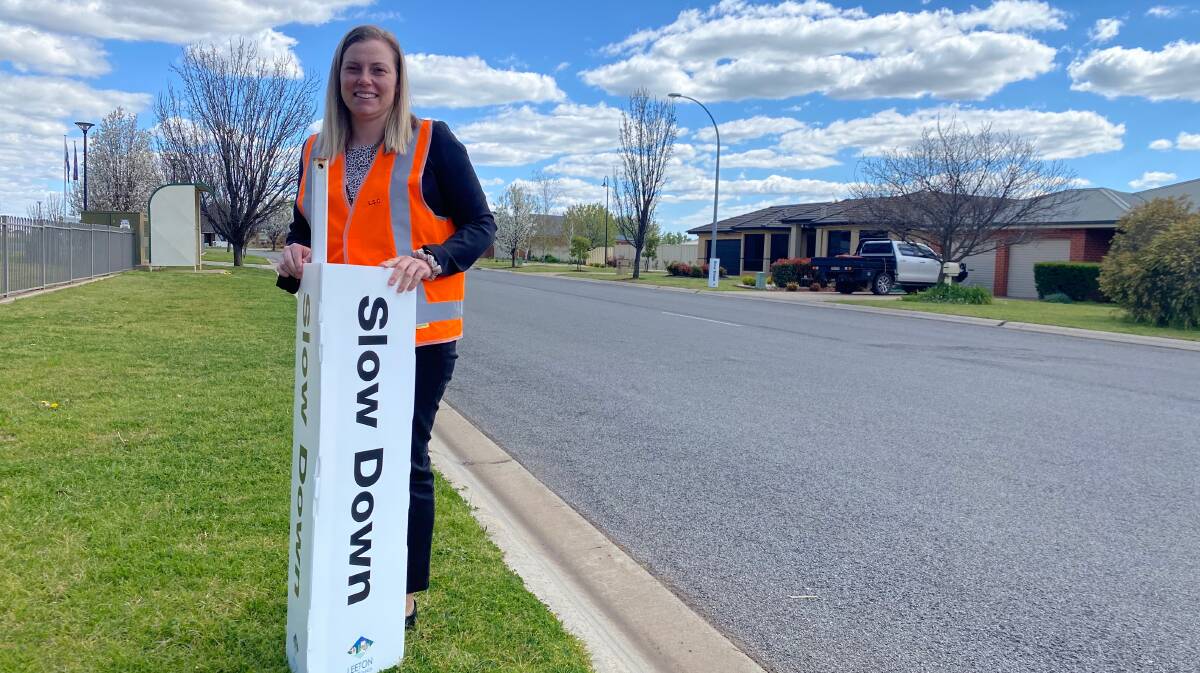 MESSAGE: Leeton Shire Council road safety officer Stephanie Puntoriero on Karri Road with some of the "slow down" boards. Photo: Talia Pattison