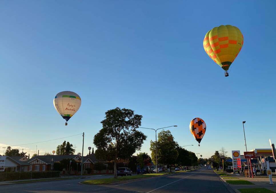 MAGIC MORNING: The hot air balloons float over Kurrajong Avenue in Leeton on Easter Sunday. Photo: Talia Pattison