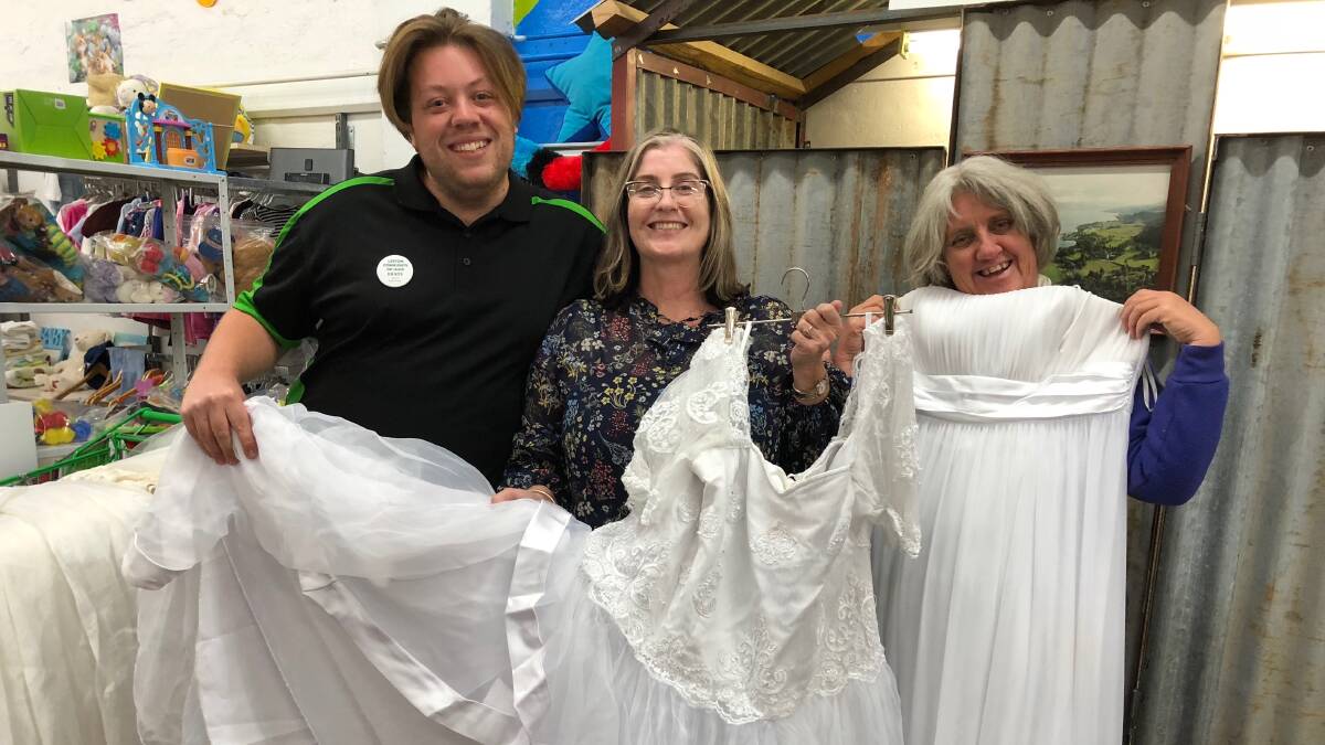 OUTFIT READY: Leeton op shop's Brady Smith (left) and Alison Cowell help Kathy McMahon find a dress for the debutante ball. Photo: Talia Pattison